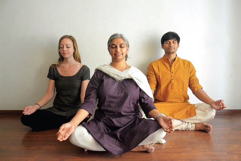 Sowmya Ayyar meditating between two fellow practitioners, from The New Indian Express feature