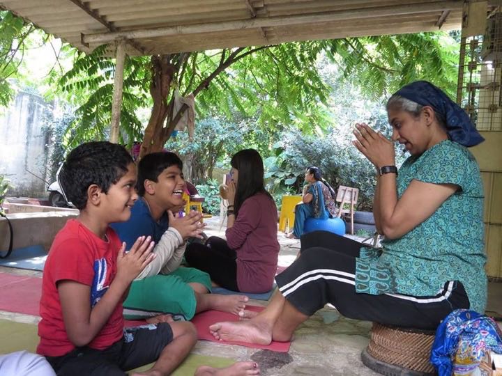 Sowmya Ayyar and laughing children in a garden yoga class, from The Better India&rsquo;s story
