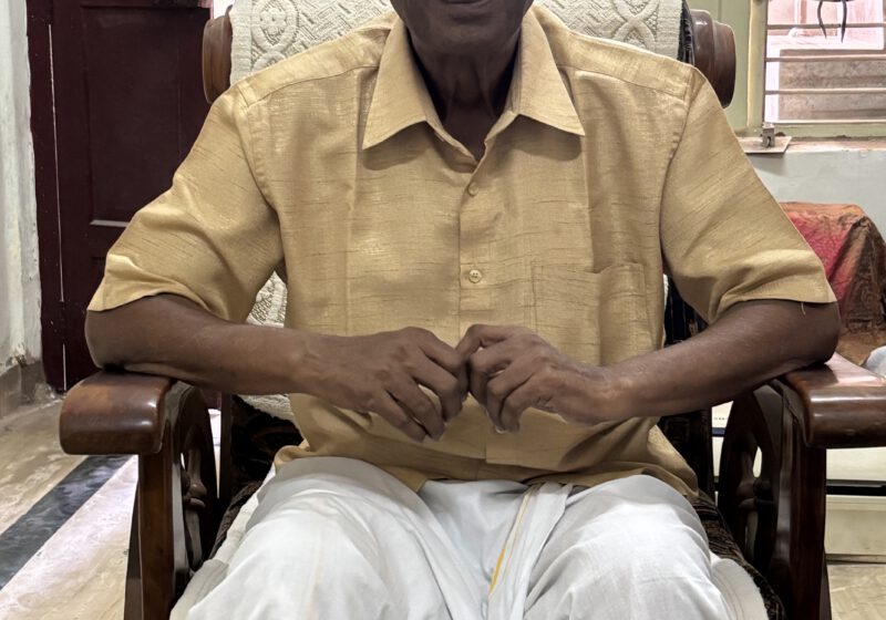 The retired headmaster wearing a light-colored shirt and a traditional dhoti, regaling me with his thoughts on Andal.